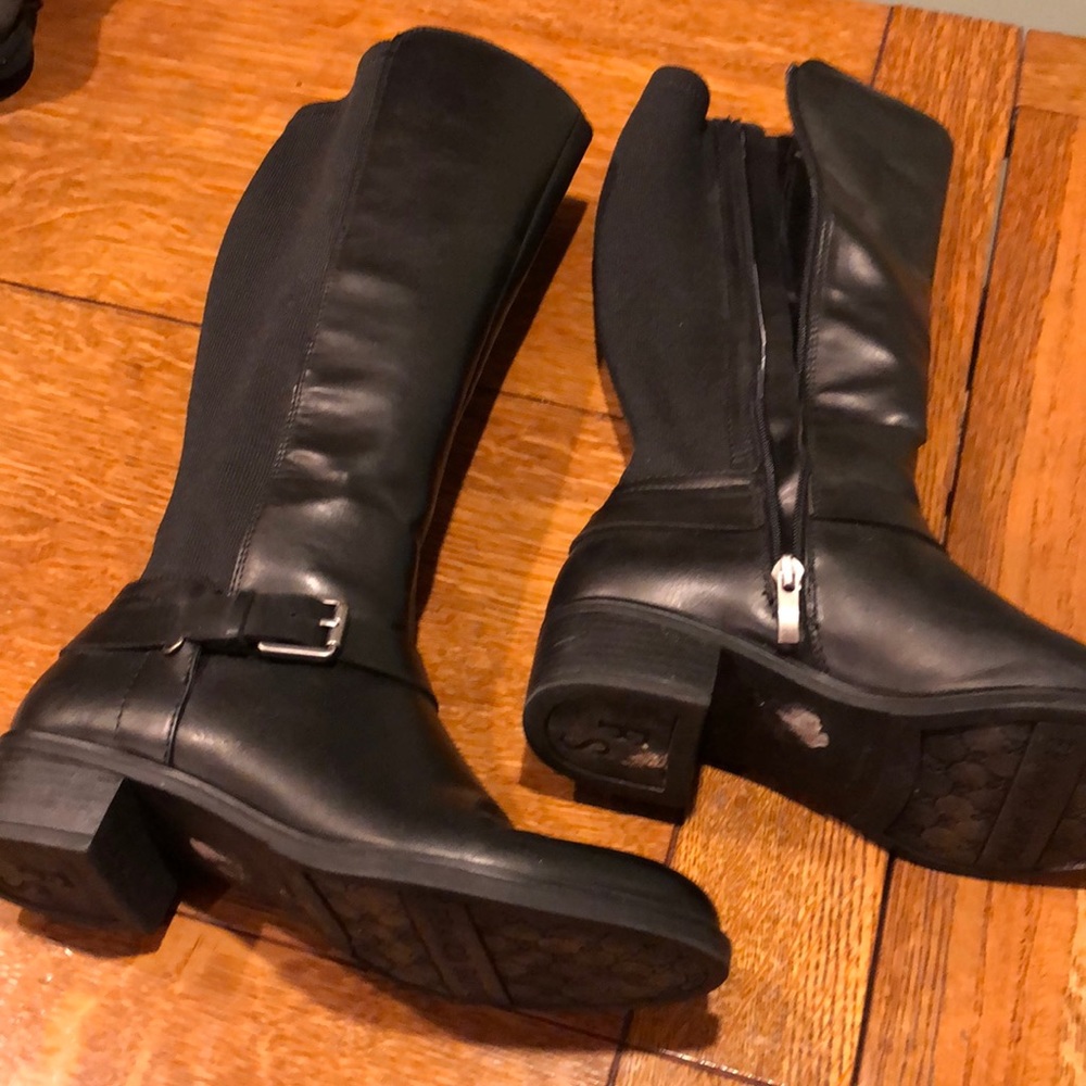 Black riding boots with a silver buckle